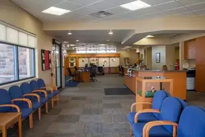 Interior of a medical clinic with chairs and a desk near a window