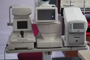 Three white medical machines on a white table, each with screens and buttons, one with a blue light.