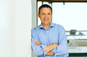 man leaning against a wall with arms crossed
