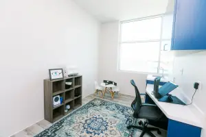An empty room with a desk, chairs, and a window