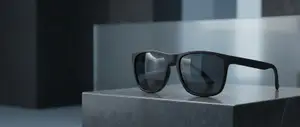 A pair of black sunglasses with a reflective lens on a marble stand