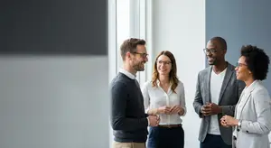 four smiling people standing in front of a window in an office building