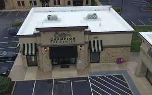 Champion Eye Center building with white roof and striped awnings