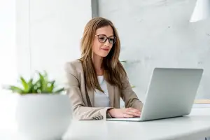 Businesswoman in a suit using a laptop in an office