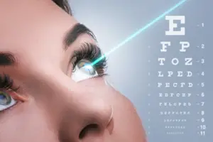 A close-up of a woman's face with an eye test chart and a laser light on her eye.