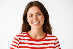 A smiling woman wearing a red and white striped t-shirt is looking at the camera with a bright smile.