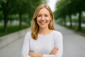 Portrait of a woman standing on a path with trees and a clear sky