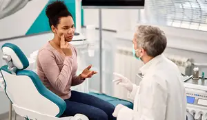 A dentist talks to a patient in a dental clinic