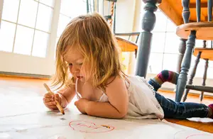 Little girl drawing on the floor