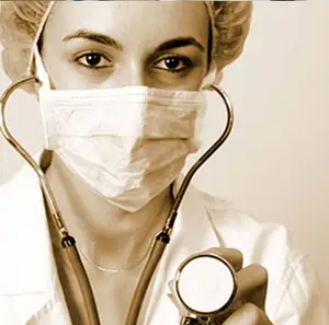 A close-up of a doctor wearing a mask, a white lab coat, and holding a stethoscope. The doctor is looking at the camera.