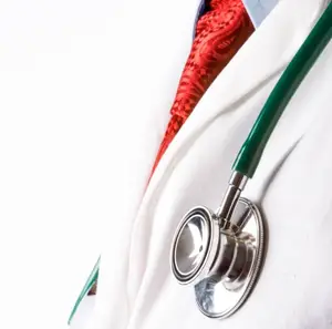 A doctor's white coat with a red tie and a stethoscope in a close-up view