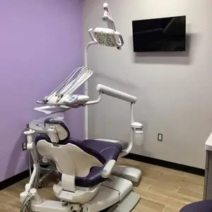 A dental room with a chair, monitor, and dental equipment