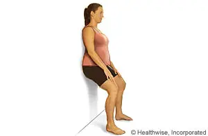 A woman doing a wall squat exercise on a white background