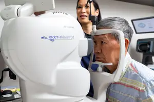 An elderly man having his eyes examined by an optometrist in a clinic.