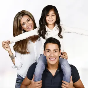 A family of three, a woman, a man, and a girl, are posing for a photo.