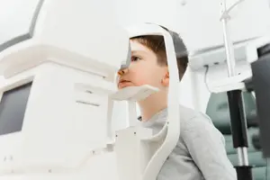 A child looking into an eye machine in a clinic