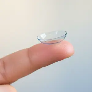 A finger with a clear contact lens on the tip.