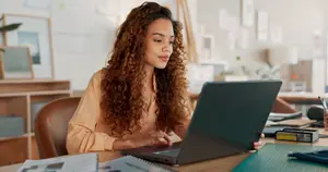 woman sitting at a desk working on a laptop