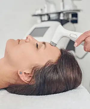 Close-up of a woman's face receiving a skincare treatment in a salon