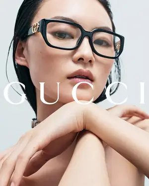 woman with black hair wearing Gucci glasses posing for a photo