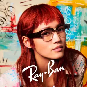A woman with red hair and glasses posing for a photo with a colorful background.