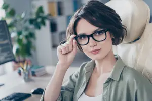 Business woman wearing glasses sitting at desk in office