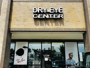 The front of the Dry Eye Center building with a man wearing sunglasses on the window glass.