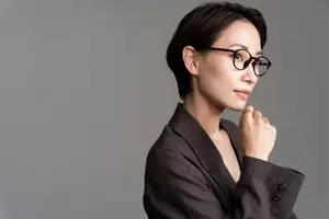 Business woman with short hair wearing glasses and a blazer