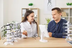 A man and woman are looking at glasses in a shop.