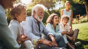 A group of people sitting on the grass, smiling and enjoying a sunny day in the park