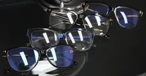 Four pairs of Tom Ford eyeglasses Houston with blue lenses and black frames displayed on a black surface