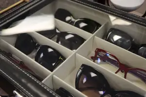 A close-up of a storage box with several pairs of sunglasses in different colors and styles.