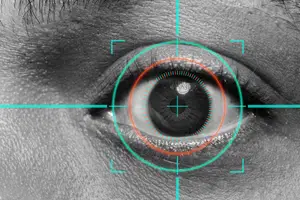 Close-up of a human eye with a green and orange circle surrounding it.