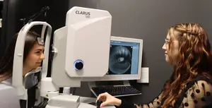 female optician performing eye exam on young female patient