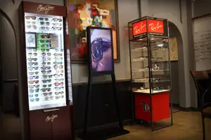 Two shelves displaying branded sunglasses store interior