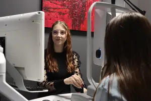 female optician performing eye exam on female patient