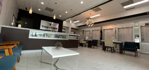 Interior of an eye care center featuring a reception desk, modern furniture, and various decorative elements.