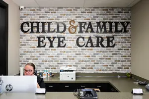 Woman working at the reception desk of a child and family eye care clinic.