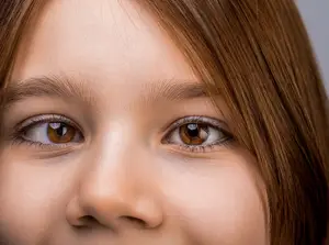 Close up of a smiling young girl with brown eyes and brown hair