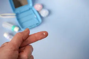 A hand pointing to a contact lens on a blue background