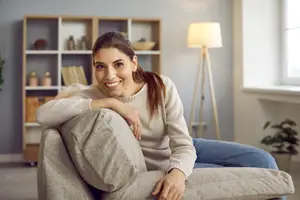 A woman sitting on a couch with a smile on her face