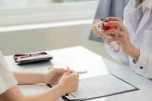 A woman doctor explaining eye condition to her patient using a model of an eyeball