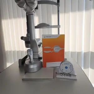 A desk with an ophthalmoscope, a box for TearCare, and a circular device