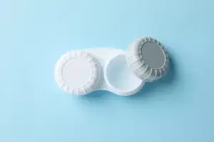 Two contact lenses in a container on a blue background