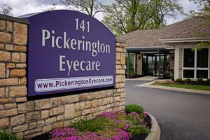 Pickerington Eyecare building exterior with a purple sign and website address on a brick wall