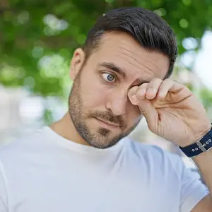 man rubbing eyes