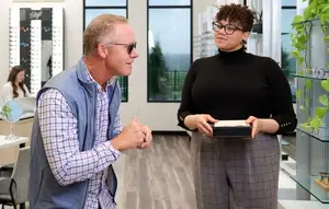 A man and a woman are standing and talking in an optical shop