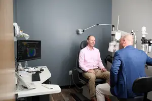 A doctor is talking to his patient in a clinic room