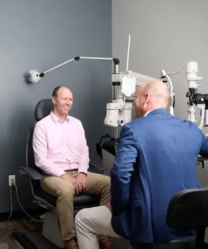 Two men having a conversation in an optometrist's office