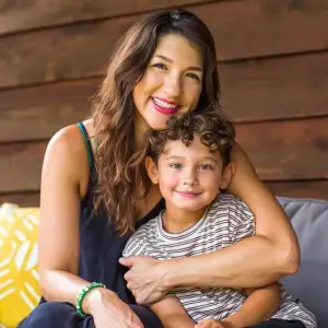 A woman and a boy are smiling and posing for a picture.